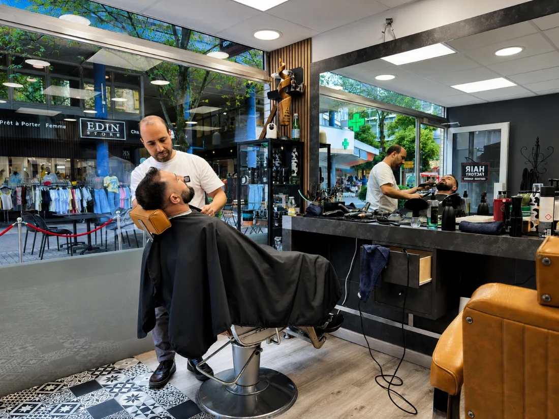 Barbier Hair Factory taillant une barbe en cabine