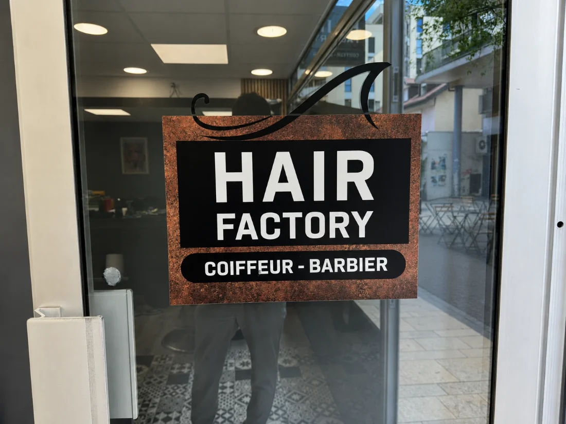 Logo Hair Factory sur la vitrine du salon